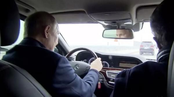 Putin, la volanul unei mașini, pe podul Crimeei. În materialul video se observă că Putin conduce un vehicul occidental